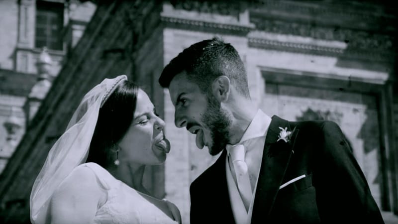 Fotografías de boda en blanco y negro de los novios sacando la lengua, un momento divertido y único.