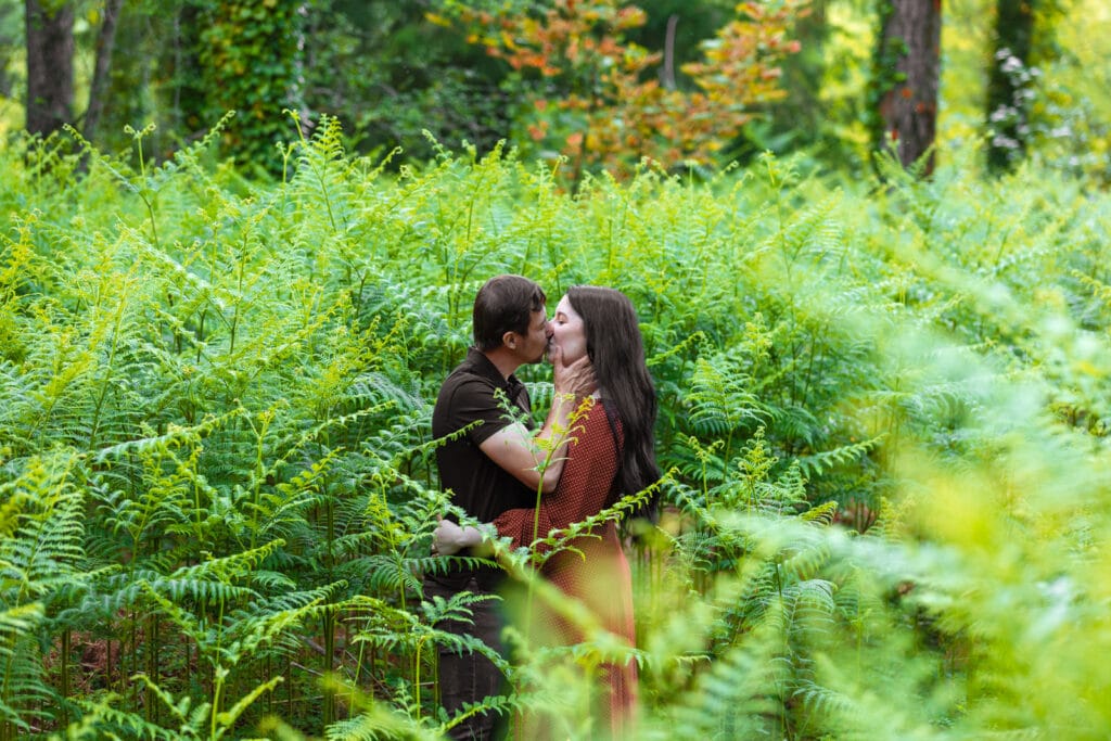 Pareja besándose en un bosque rodeado de helechos – Fotógrafo de bodas en Madrid