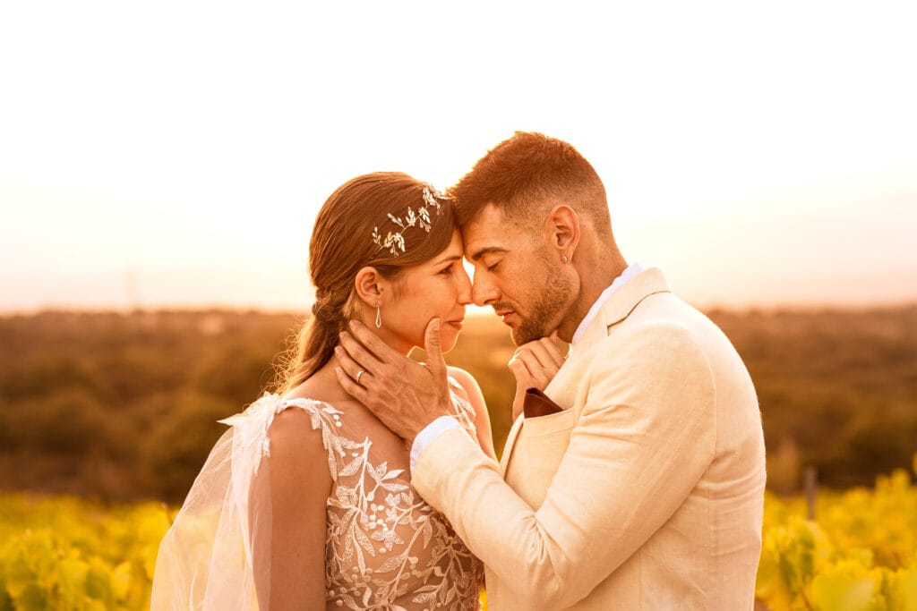 Enamorados sin posados artificiales, uno frente al otro en un campo al atardecer con luz cálida naranja
