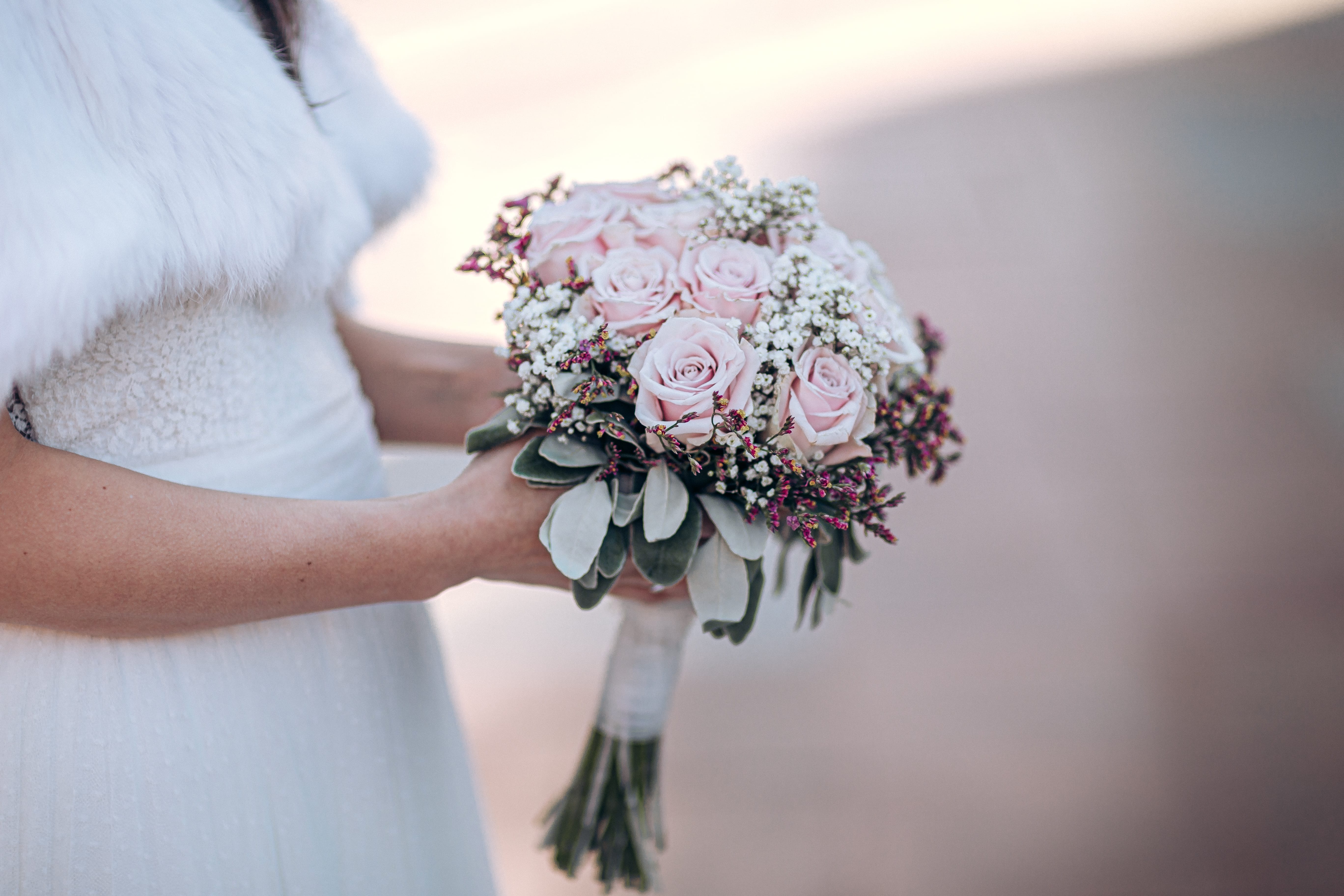 El ramo con colores pastel, cogido por la novia de perfil